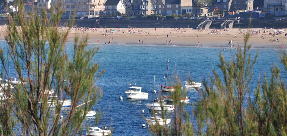 Vue sur la plage de Saint-Lunaire avec des bateaux amarrés au premier plan
